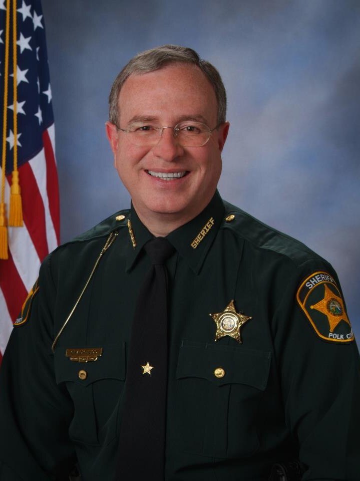 Professional head shot of Sheriff in uniform in front of the American flag.