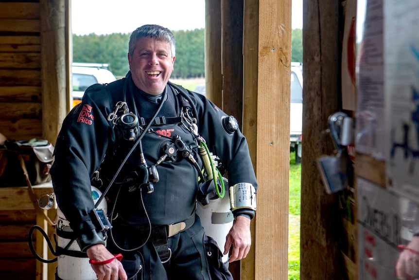 A diver with oxygen tanks and diving gear.