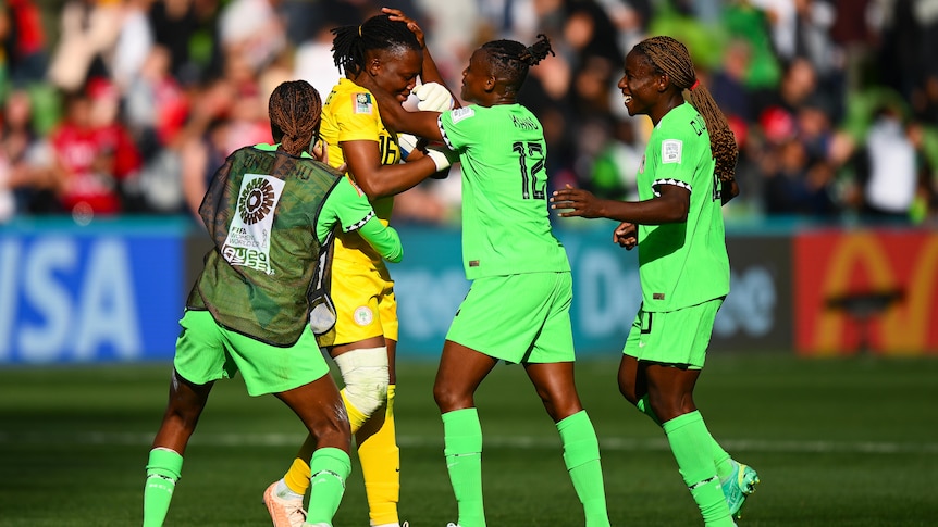 Three Nigeria teammates celebrate with Chiamaka Nnadozie after the Women's World Cup match against Canada.