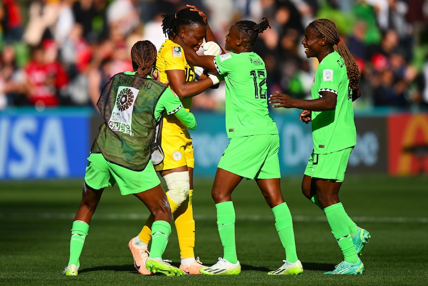 Three Nigeria teammates celebrate with Chiamaka Nnadozie after the Women's World Cup match against Canada.