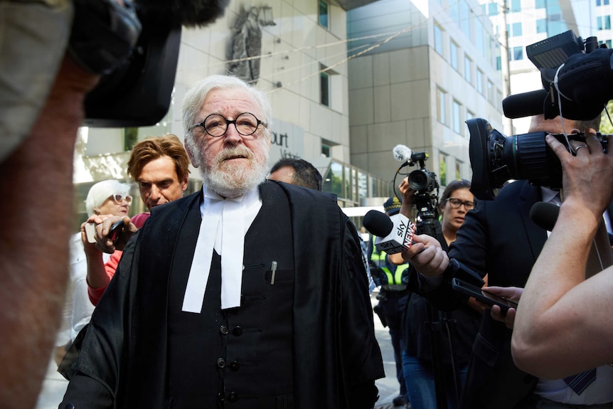 Robert Richter surrounded by media outside court.