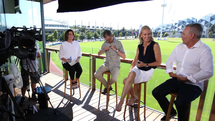 Kelli Underwood and panellists sitting on stools with camera equipment in foreground.