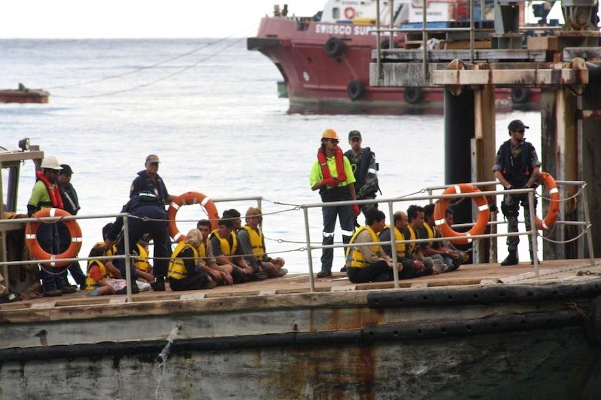 Asylum seekers are moved ashore at Christmas Island.