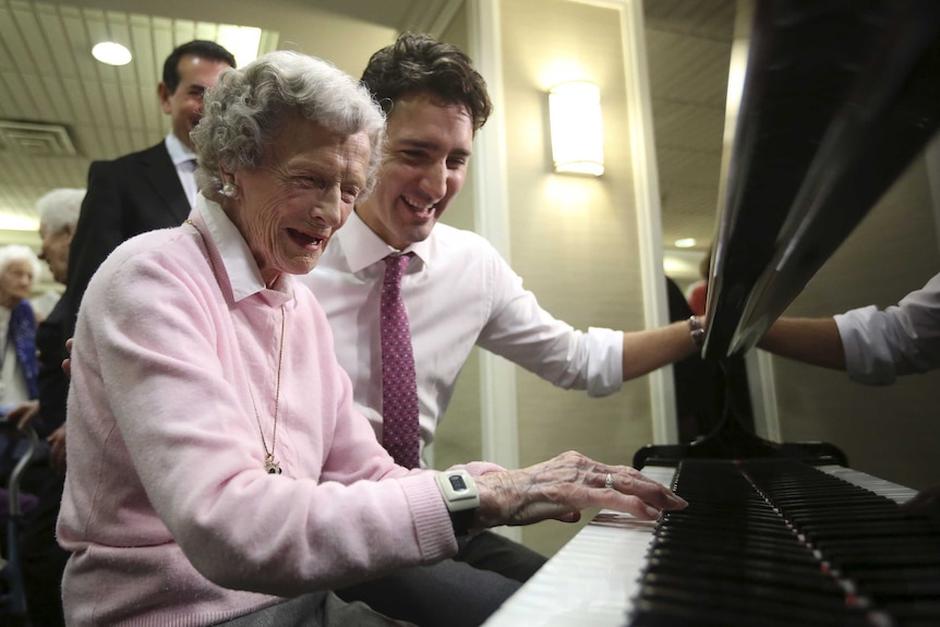 Justin Trudeau watches woman play piano