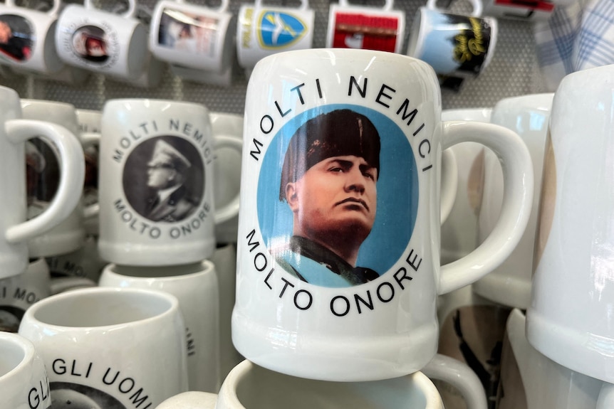 Una tazza con una foto del dittatore italiano Mussolini con testo in italiano