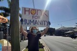 A protester holds up a sign that says 'Hong for Humanity'.
