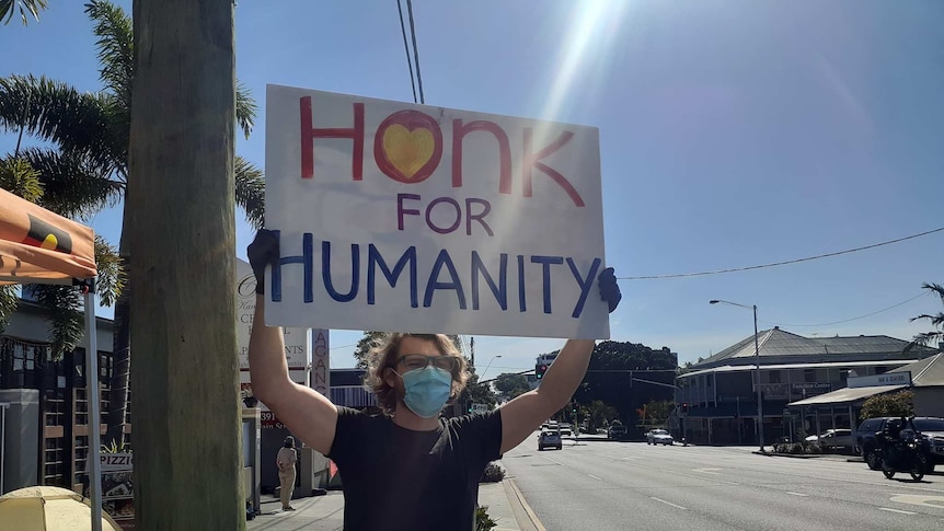 A protester holds up a sign that says 'Hong for Humanity'.