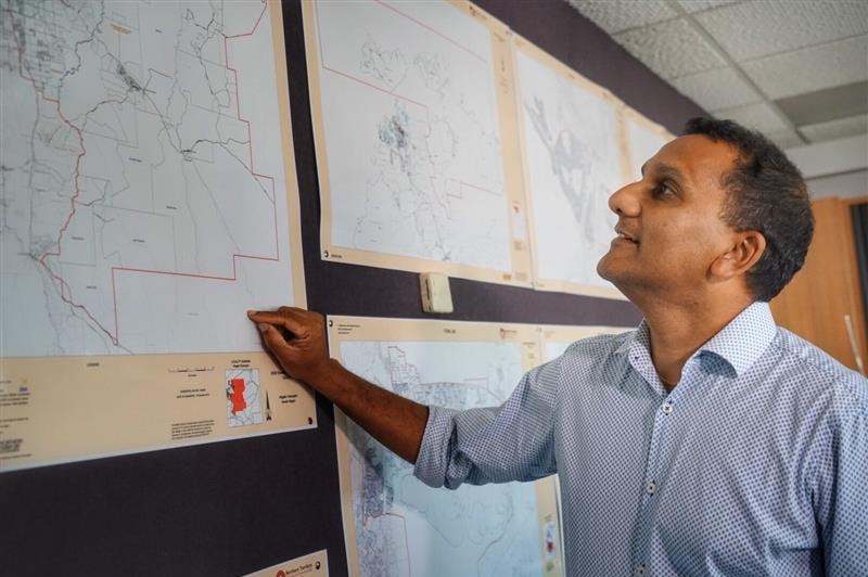 NT Electoral Commissioner Iain Loganathan looking at maps of electoral boundaries, April 2020.