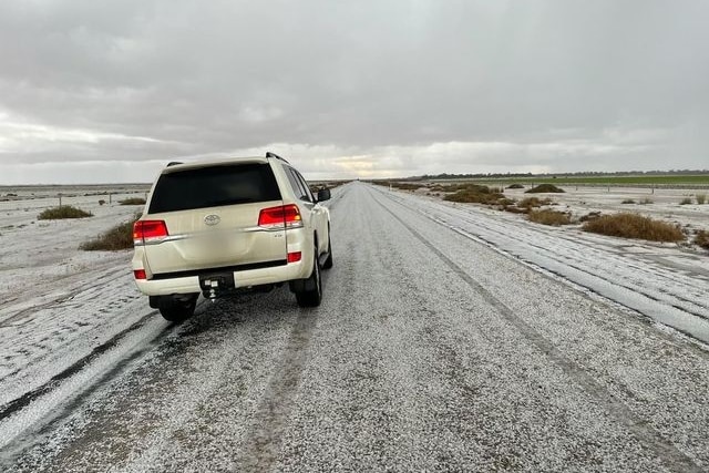 a car on a road covered in hailstones