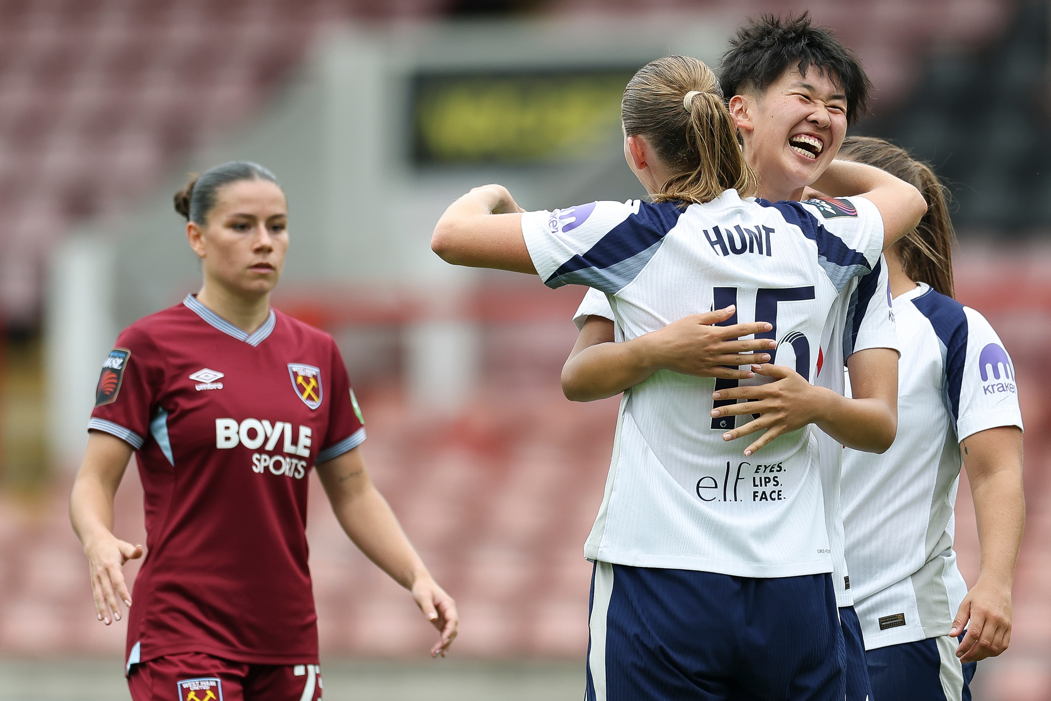 Toko Koga, do Tottenham Hotspur, comemora com Clare Hunt e dá um abraço em campo.