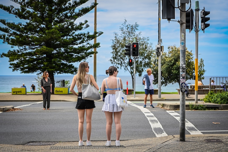 Two young girls looking to cross the road.
