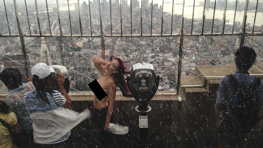 Woman poses topless on Empire State Building
