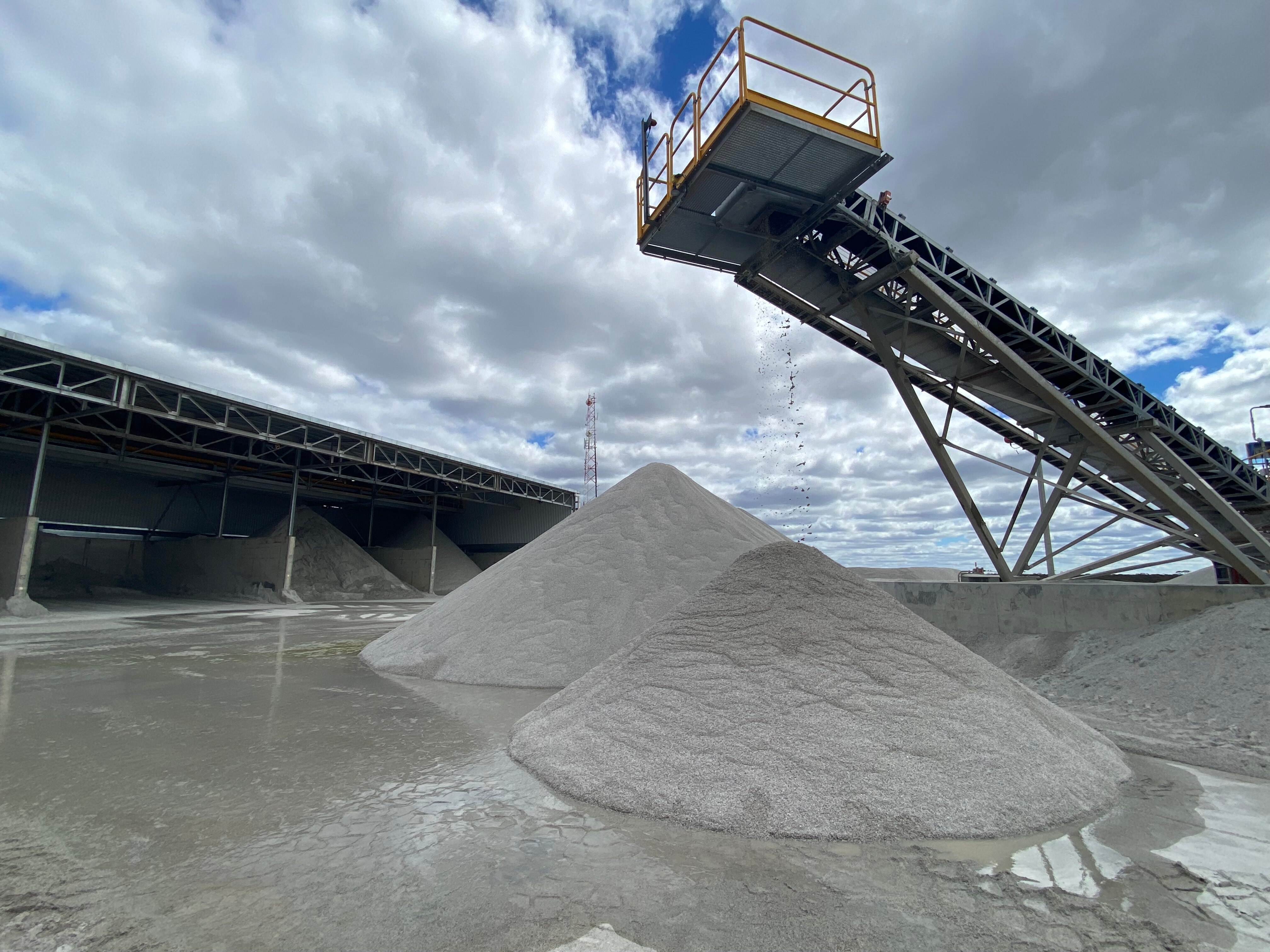 Two piles of grey rocks under some machinery.