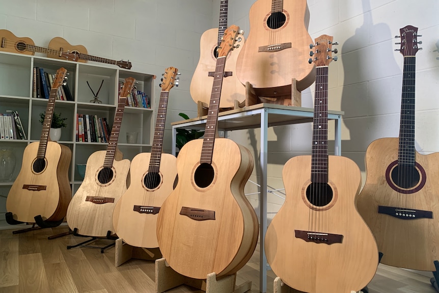 Rows of wooden guitars on stands.