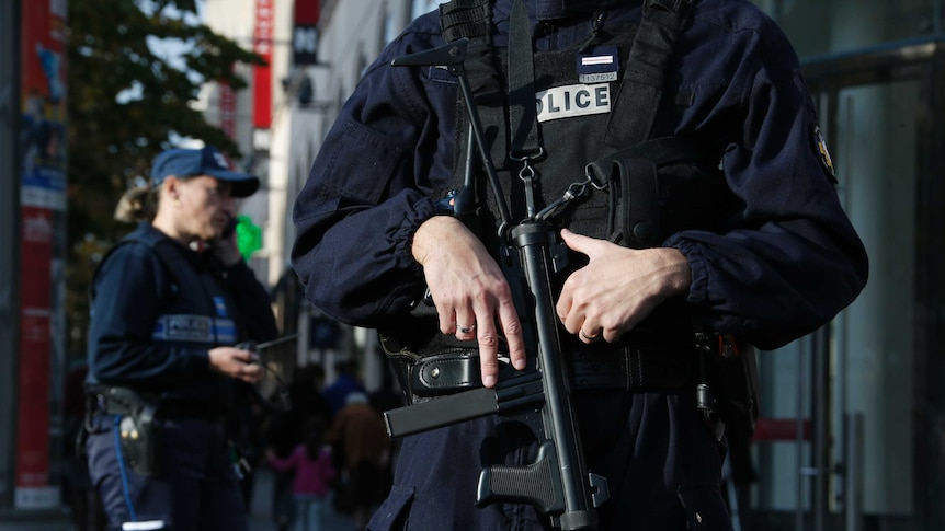 French police with guns stand outside a commercial centre in Nice.