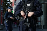 French police with guns stand outside a commercial centre in Nice.