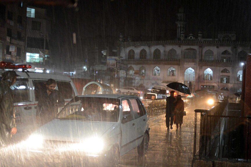 Pakistani people drive their vehicles during heavy rain in Peshawar, Pakistan