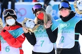 Kokomo Murase, Anna Gasser,  and Zoi Sadowski-Synnott hold their Games mascot dolls for a photo