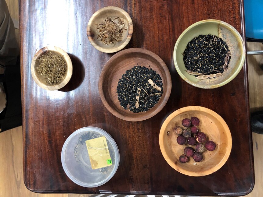 A top-down view of various nuts and grains in small bowls on a table 