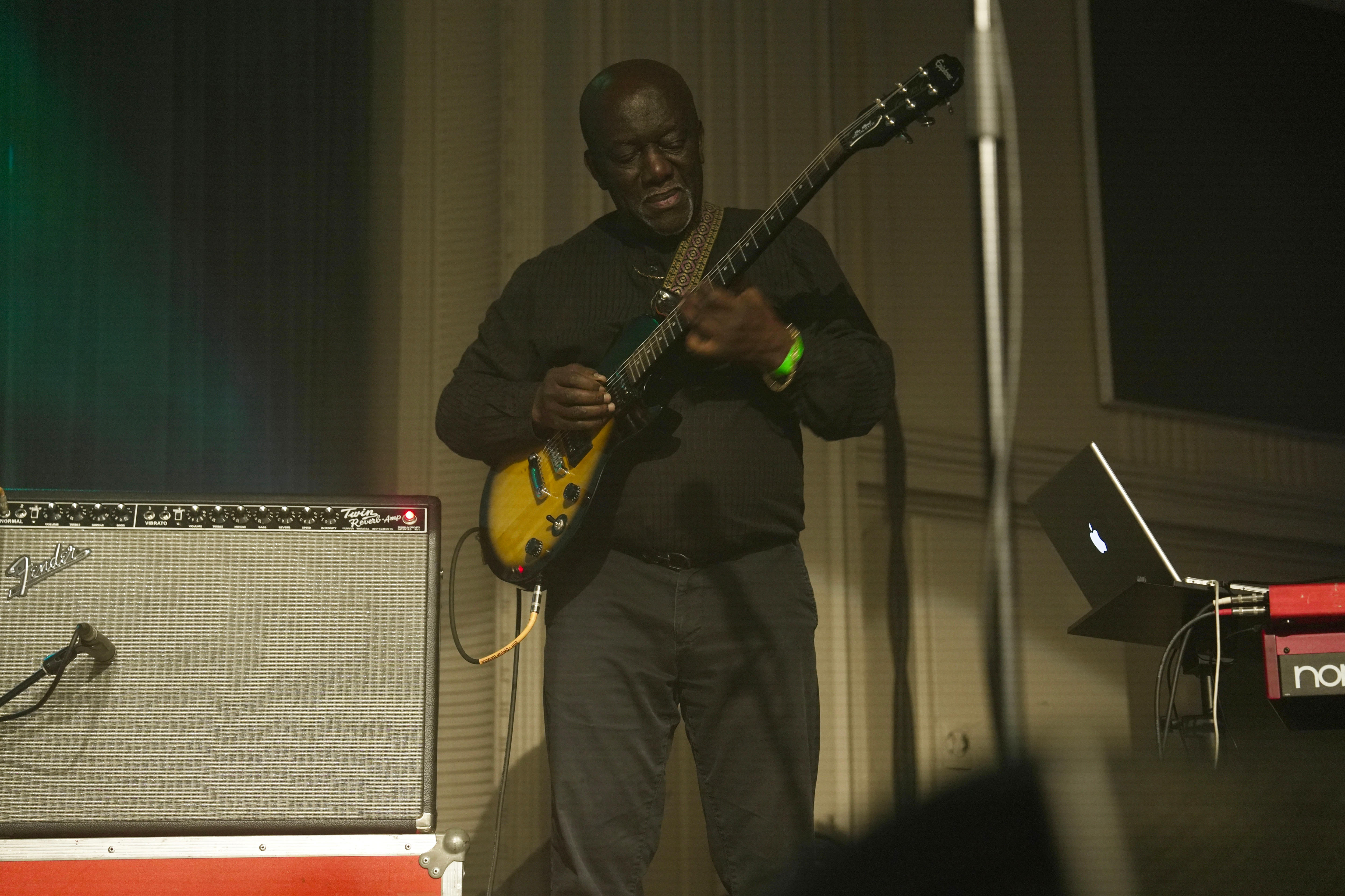 A man playing guitar on stage.