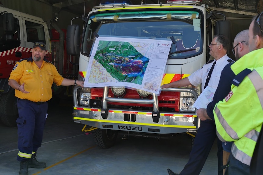 Crew use map attached to fire truck to explain the spread of the fire