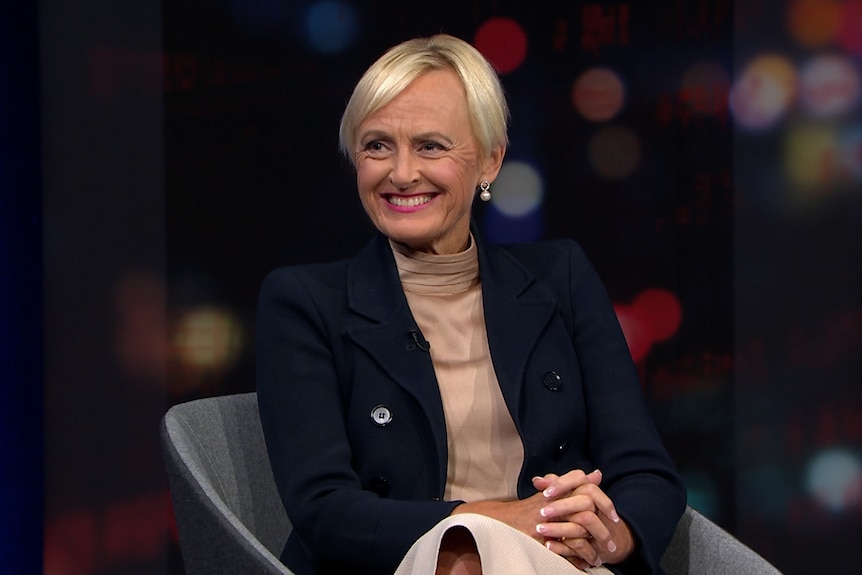 Woman sitting on a panel show smiling