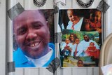 Photos of Alton Sterling are taped to the wall at a makeshift memorial outside the Triple S convenience store.