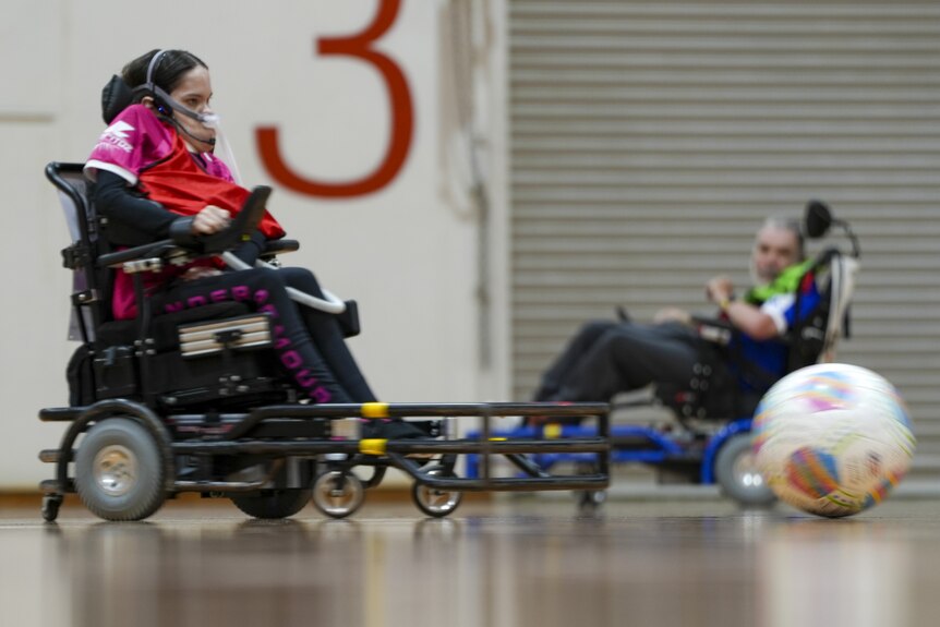 Rebecca Evans chases down the ball in front of her powerchair.