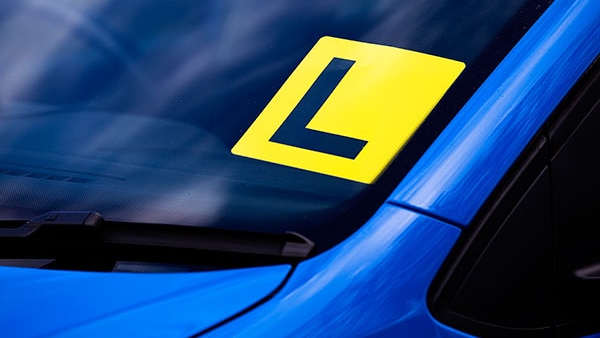 Close up of a L-plate on a blue car.