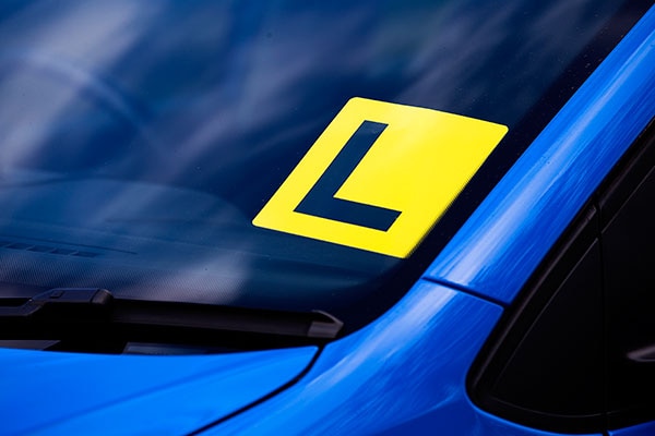 Close up of a L-plate on a blue car.