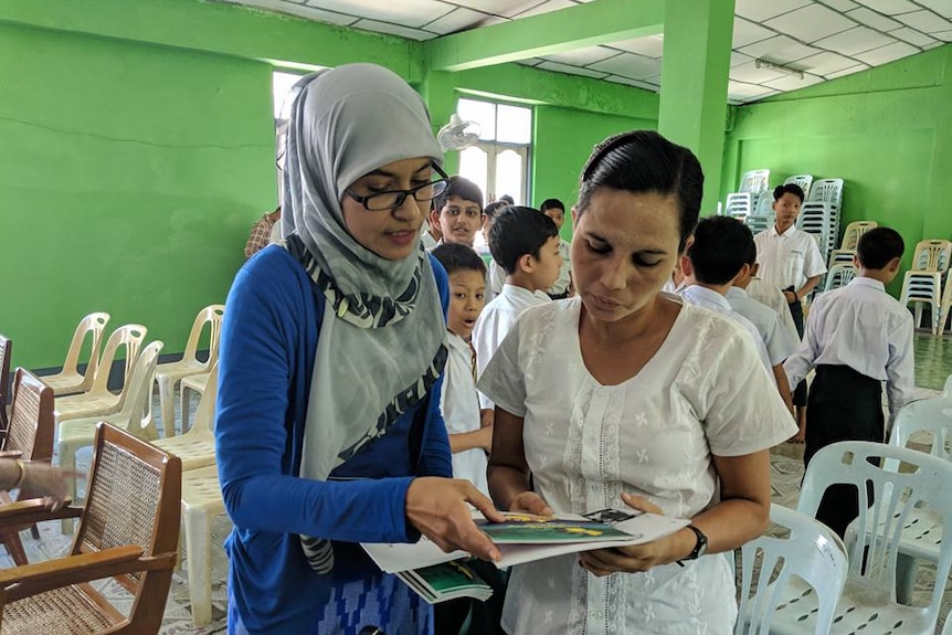 Dr Thet Su Htwe talks with another woman in school classroom