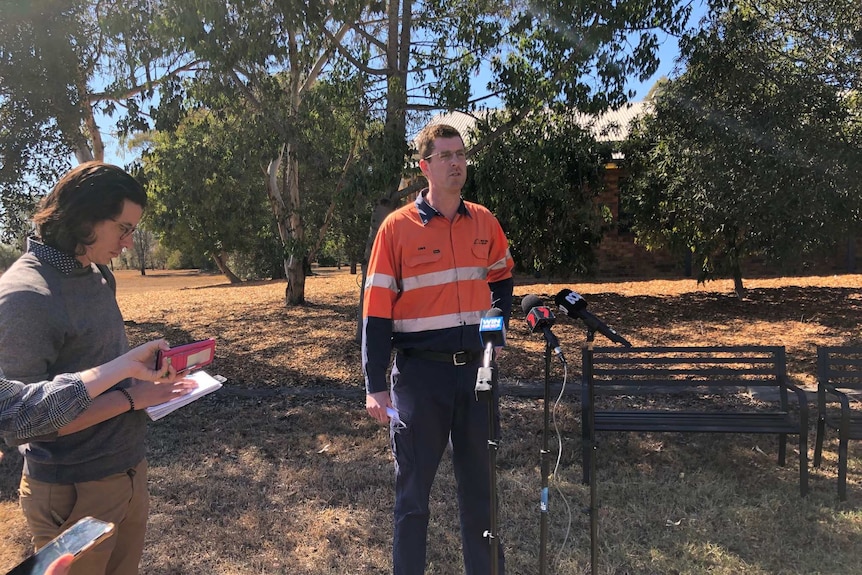 Mr O'Dwyer in high vis clothing speaks to media at press conference.