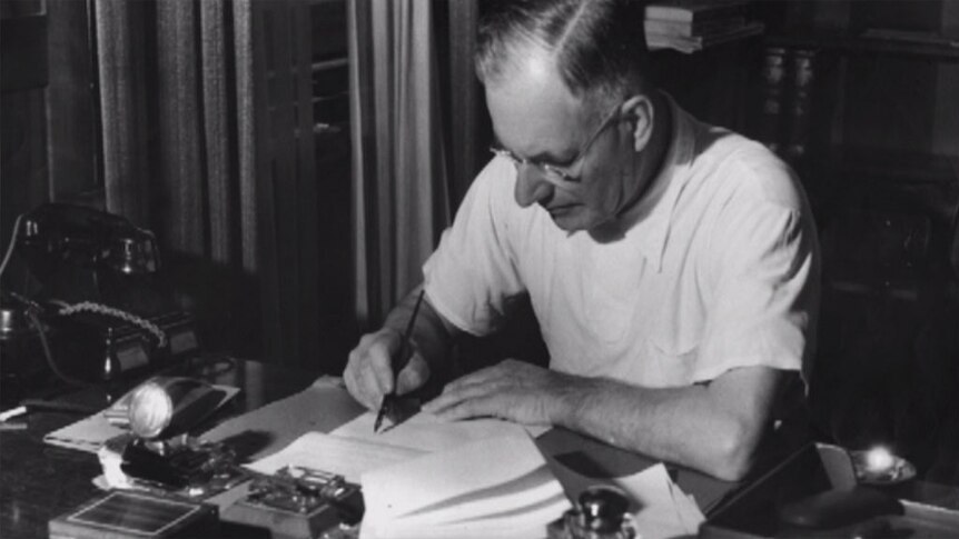 John Curtin sits at desk with document