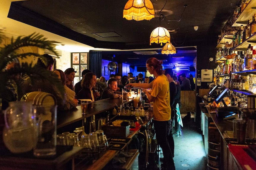 Patrons wait at the bar at Black Bear Lodge