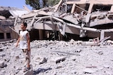 A Libyan boy stands amid the rubble outside the rubble of a school in Zliten.