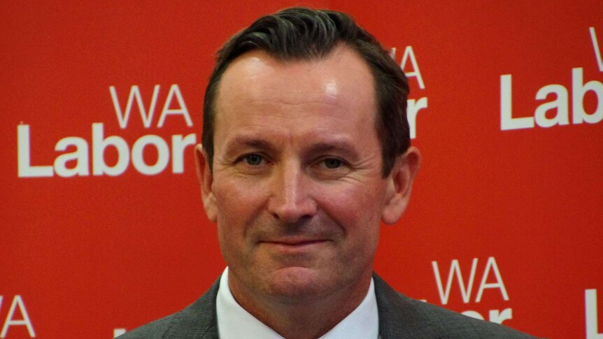 Opposition Leader Mark McGowan stands at a podium smiling after beating back potential leadership challenge from Stephen Smith.