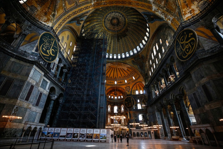 Visitors inside the Hagia Sophia mosque, which shows inside the domes with Islamic calligraphy.