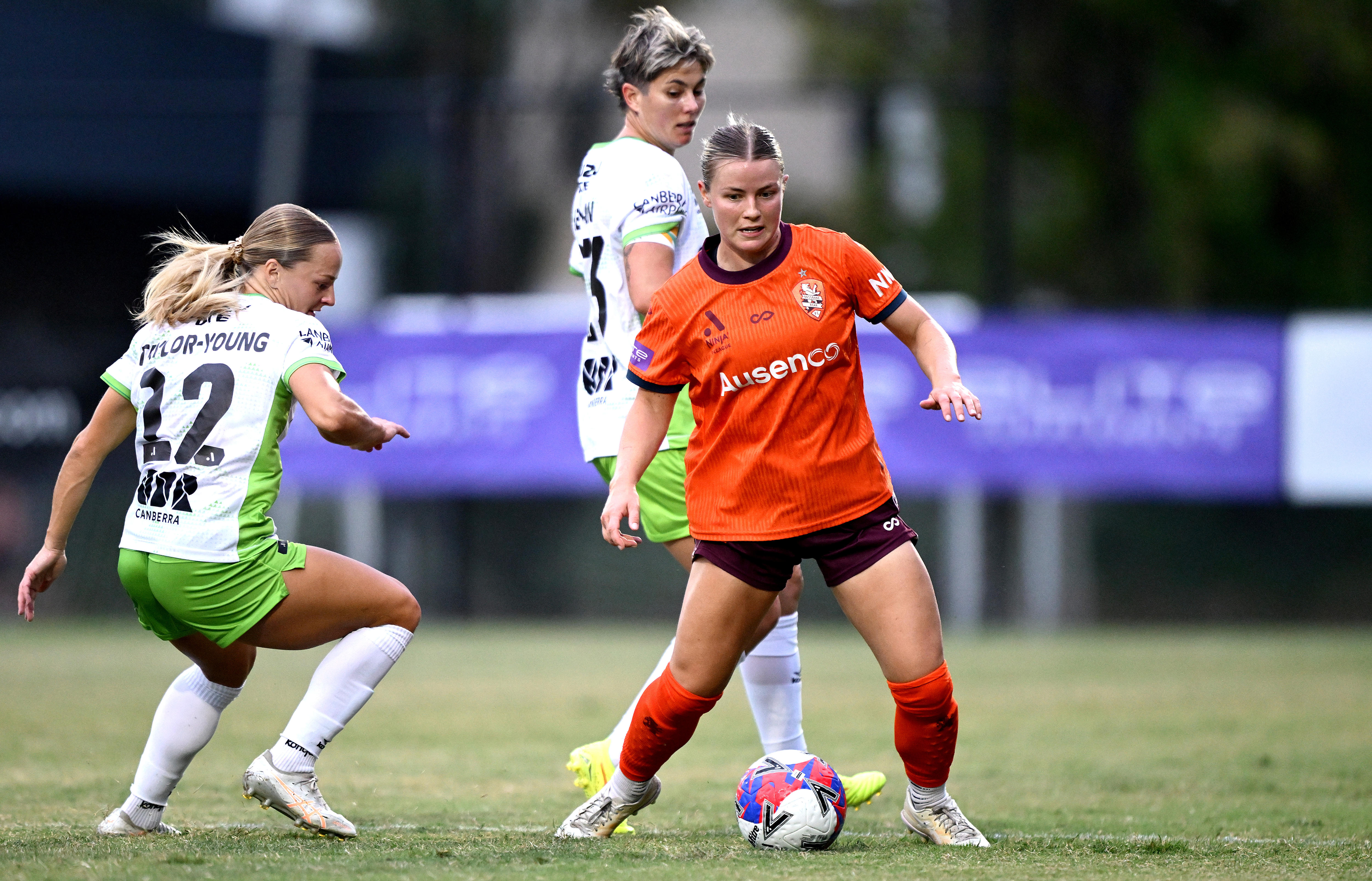 Aimee Medwin kicks the ball around two defenders.