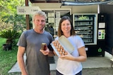 The couple stand in front of a vending machine loaded with eggs and honey.