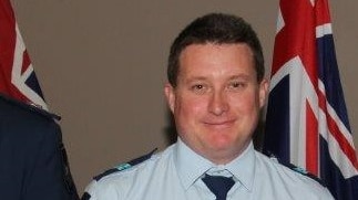 Queensland Police Service Senior Constable Brett Forte holding a medal