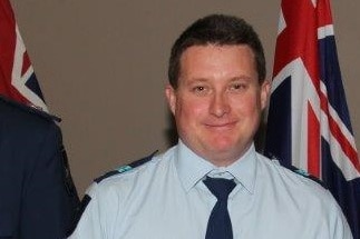 Queensland Police Service Senior Constable Brett Forte holding a medal