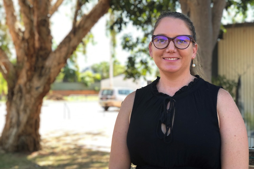 A woman with glasses smiling at the camera