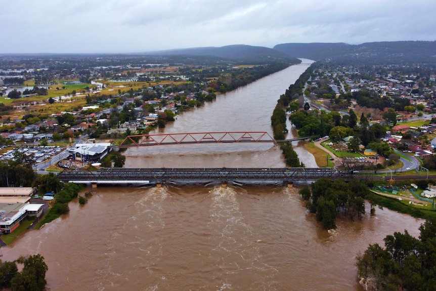An aerial view of a river swollen with brown water.