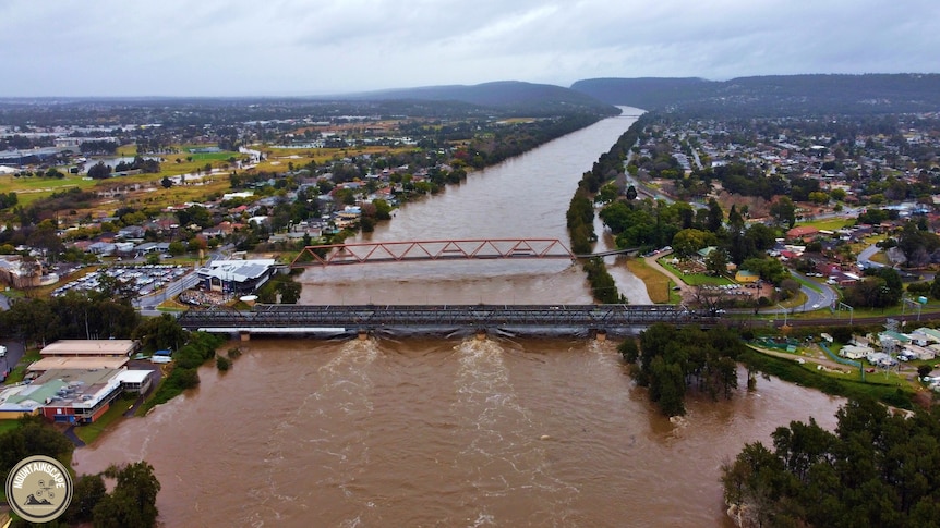 An aerial view of a river swollen with brown water.