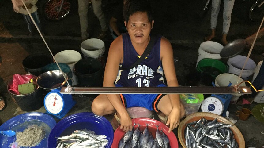A man selling fish at the night markets in Cotabato City in the Philippines.