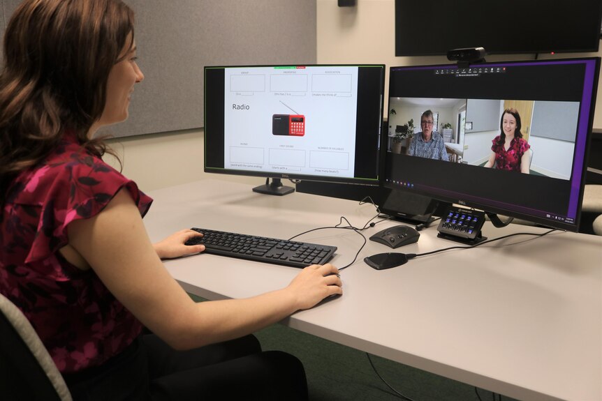 A woman sit in front of a computer talking to a man over video call software. 