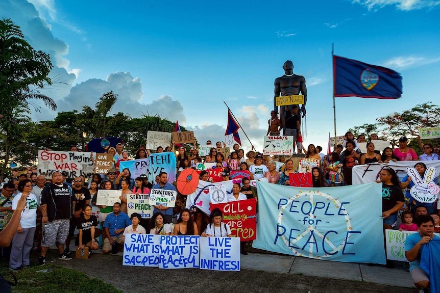 A crowd of protestors in Guam hold signs and banners at a public rally in response to the North Korean crisis.
