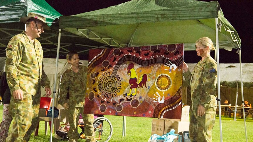 Army personnel unveil indigenous artwork containing their mascot of a rooster