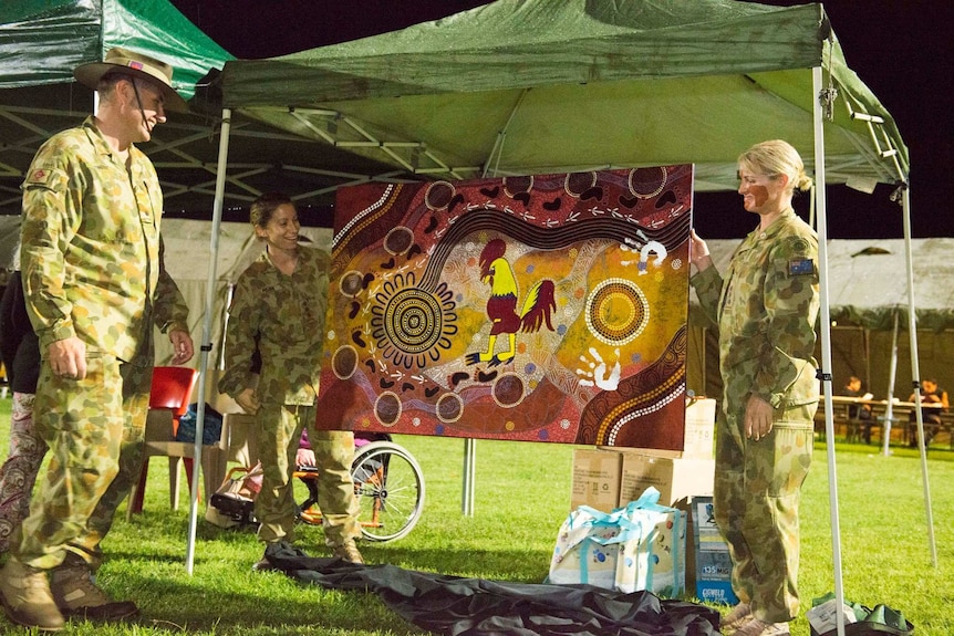 Army personnel unveil indigenous artwork containing their mascot of a rooster