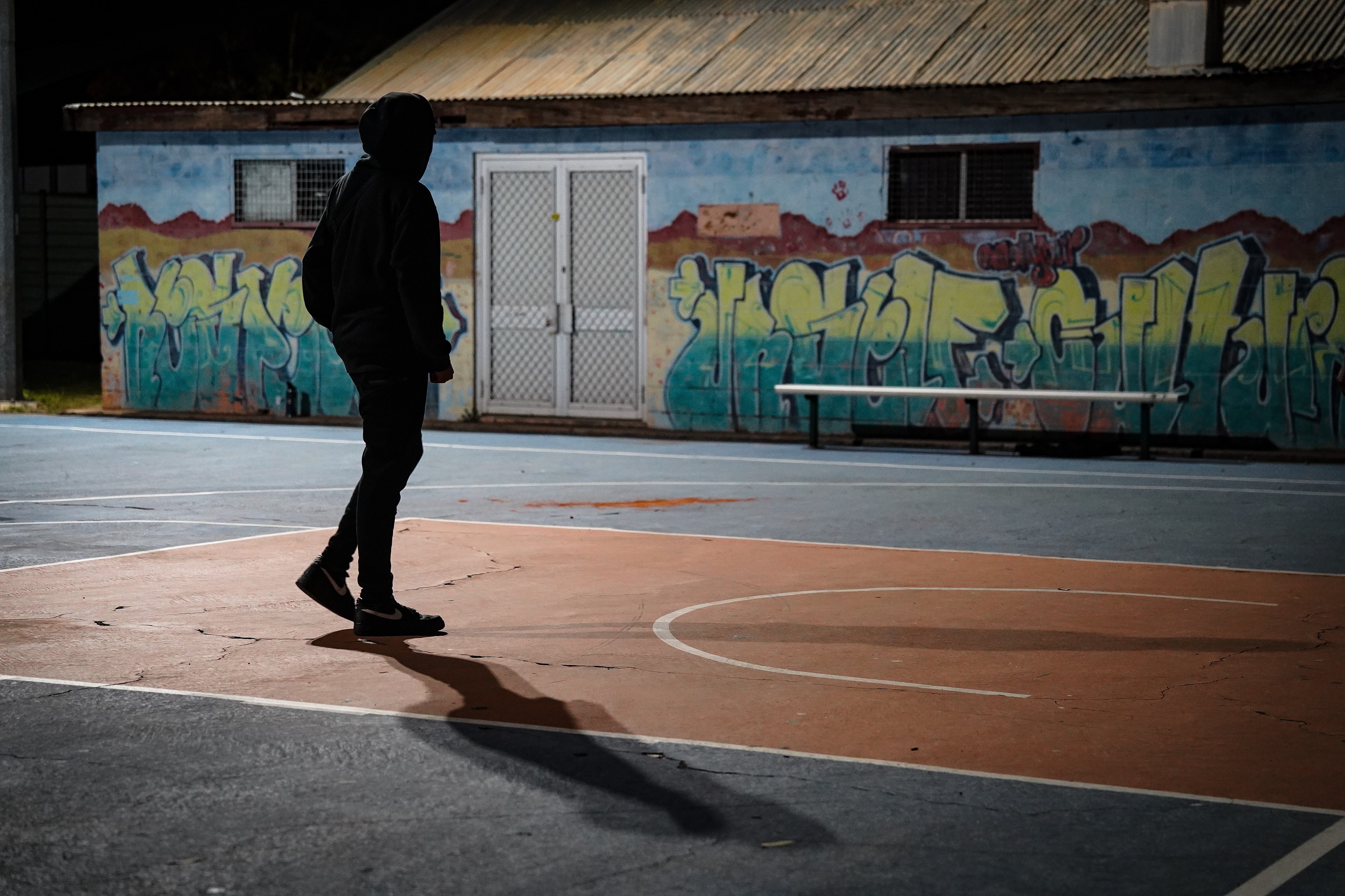 An unidentified Indigenous teenager on a basketball court.